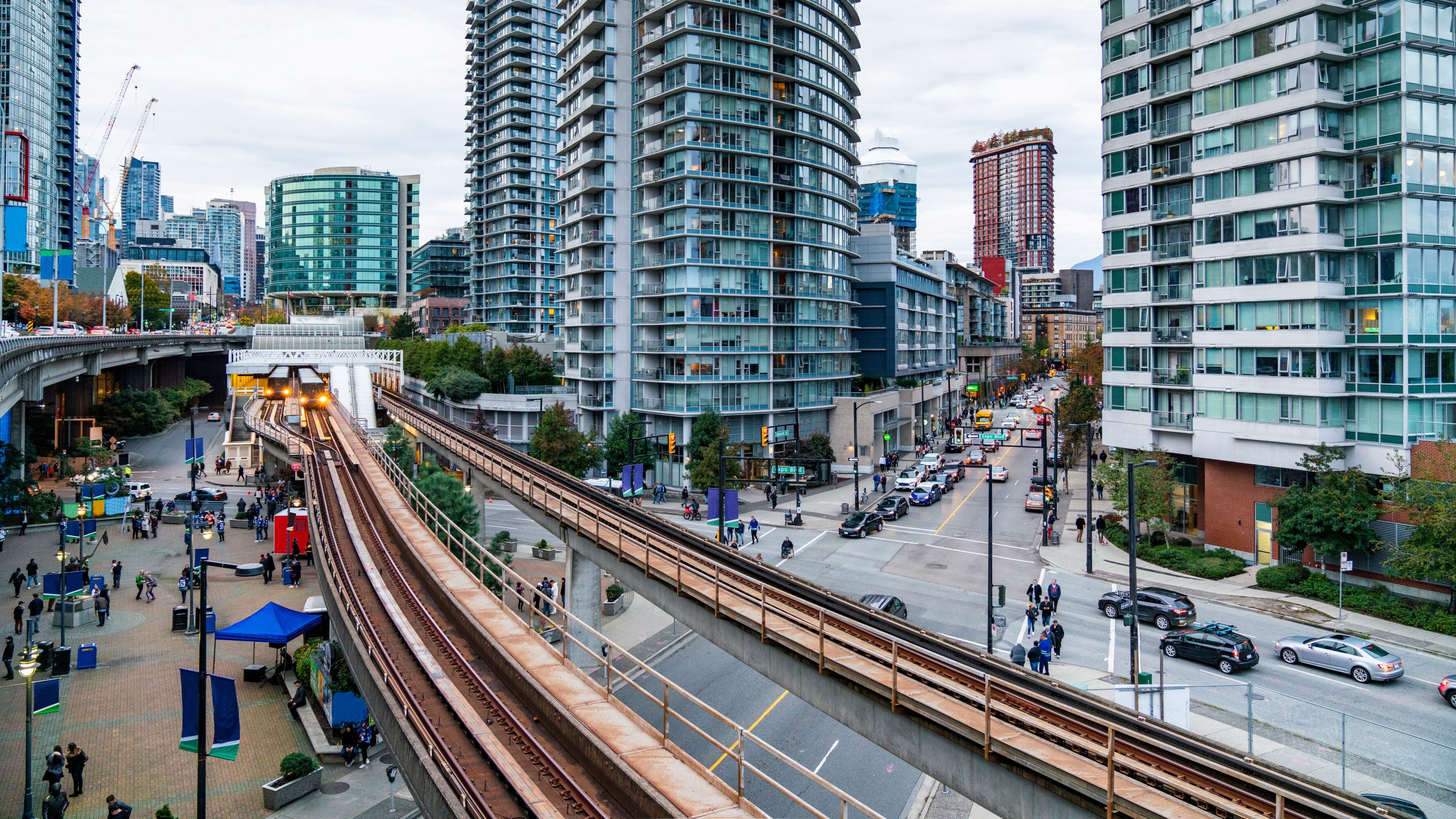 Downtown Vancouver. Skytrain in Downtown Vancouver, with people just about attending to a game on the city`s arena.